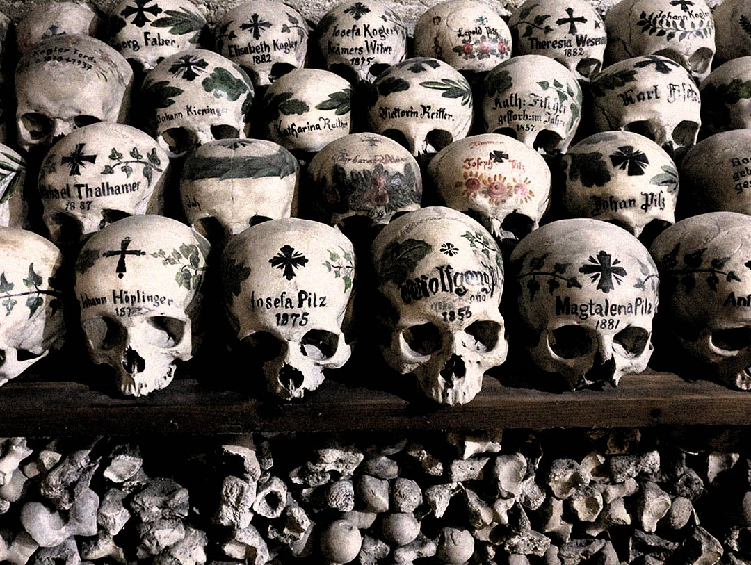 Painted skulls stacked inside Hallstatt’s Beinhaus charnel house